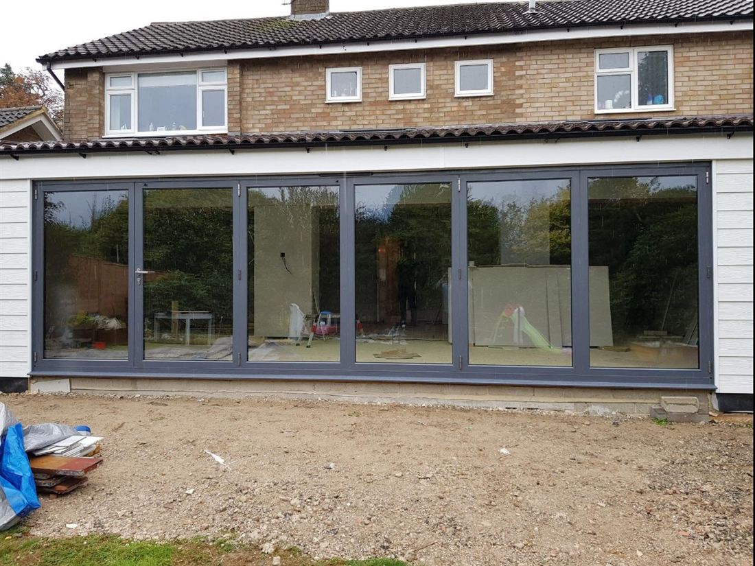Six-panel anthracite grey aluminium bifold doors across the full width of a rear extension