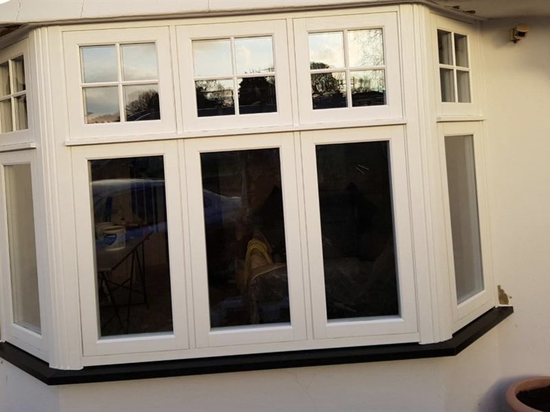 White uPVC bay window with Georgian bar top lights, fitted to a rendered house
